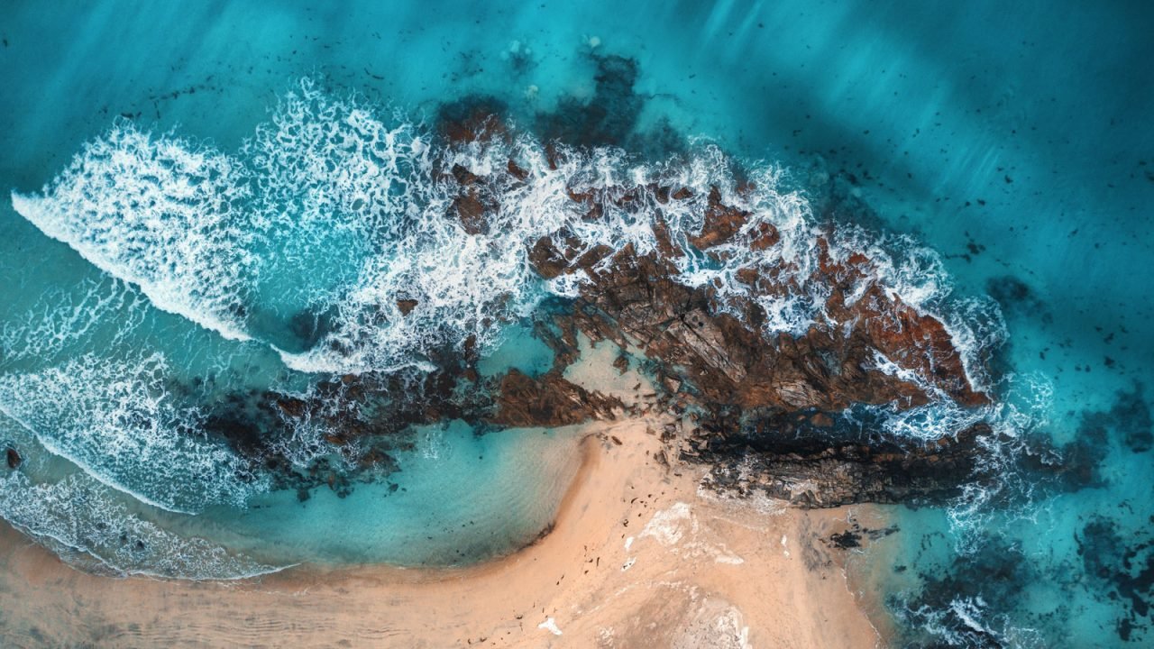 aerial-view-of-waves-rocks-and-transparent-sea-PYQ8E3R.jpg